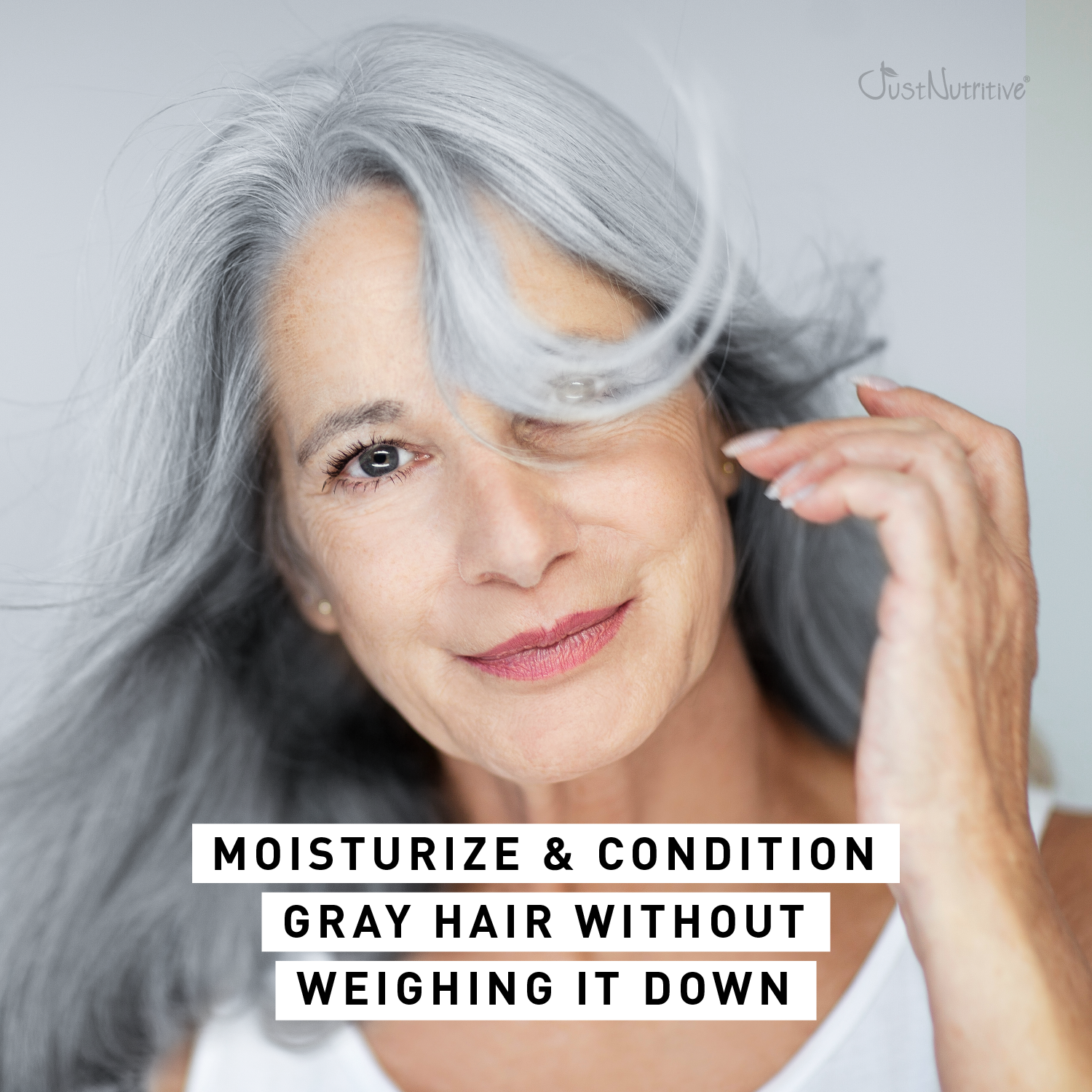 Woman with gray hair touching her hair, with text about moisturizing and conditioning gray hair.