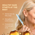 Woman combing her hair with a bottle of hair care product on a beige background